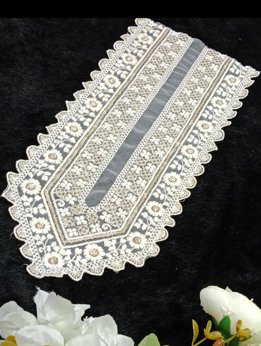 Decorative lace table runner with floral arrangement on a black background